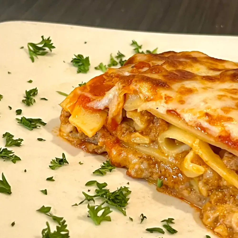 Layered lasagna with melted cheese and house meat sauce